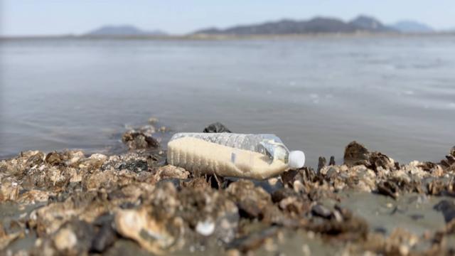 Botella con arroz en el mar